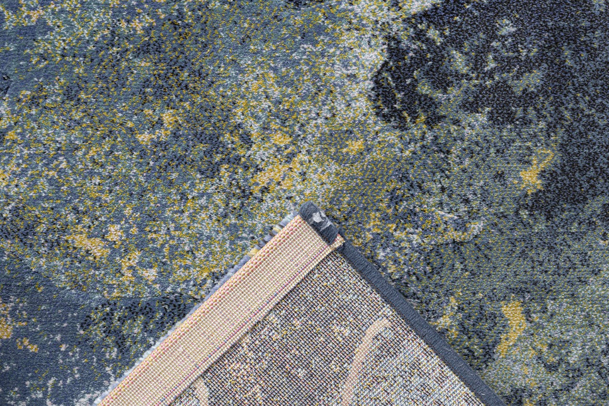 Coin replié montrant l'envers tissé du tapis bleu Tapison Home Torino 063.0934.5241
