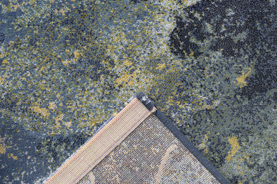 Coin replié montrant l'envers tissé du tapis bleu Tapison Home Torino 063.0934.5241