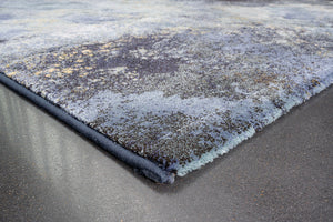 Détail d'un angle du tapis Tapison Home Torino 063.0934.5241 en bleu, vert sauge et ocre