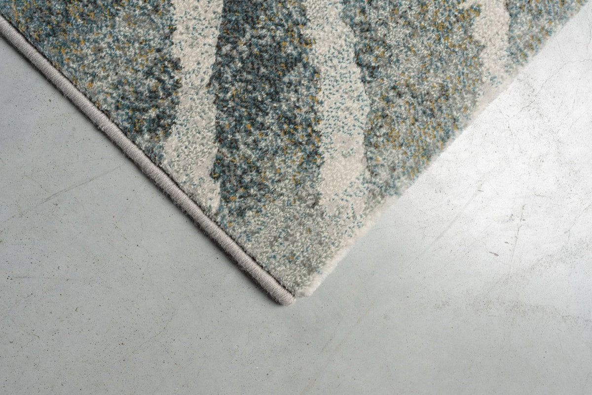 Détail d'un angle du tapis Tapison Home Torino 063.0990.4299 en vert et gris