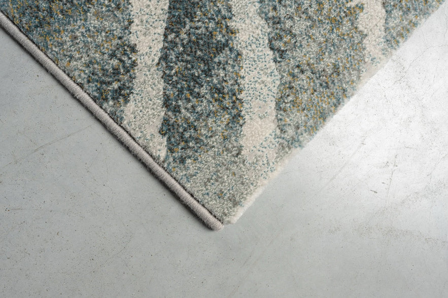 Détail d'un angle du tapis Tapison Home Torino 063.0990.4299 en vert et gris