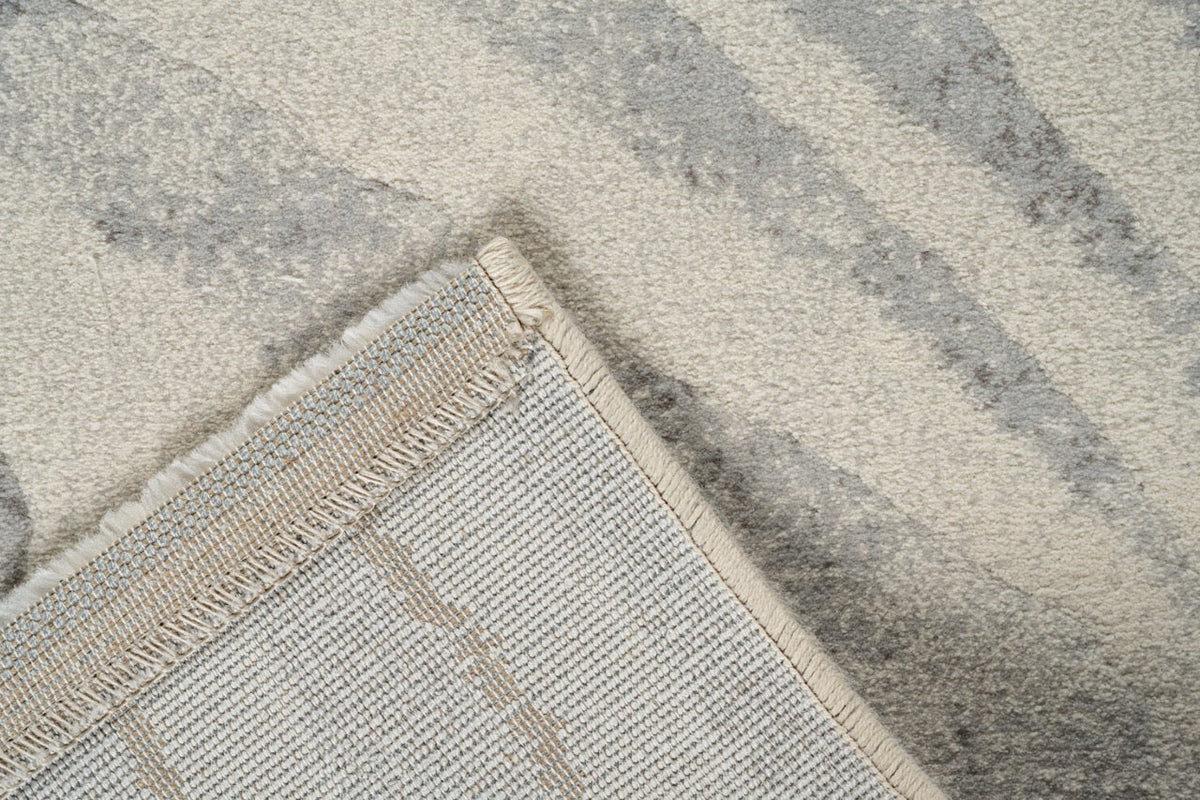 Coin replié montrant l'envers tissé du tapis ivoire Tapison Home Torino 063.0990.6797