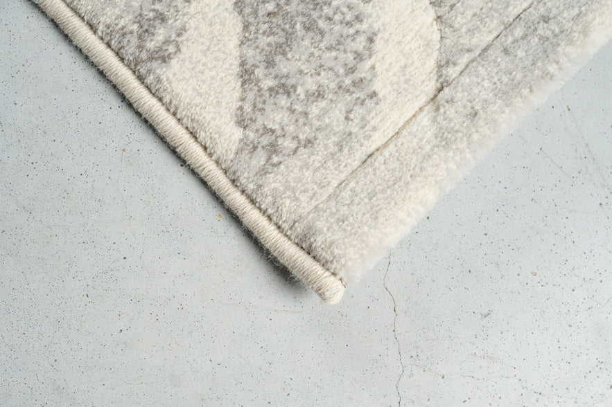 Détail d'un angle du tapis Tapison Home Torino 063.0990.6797 en ivoire et gris clair