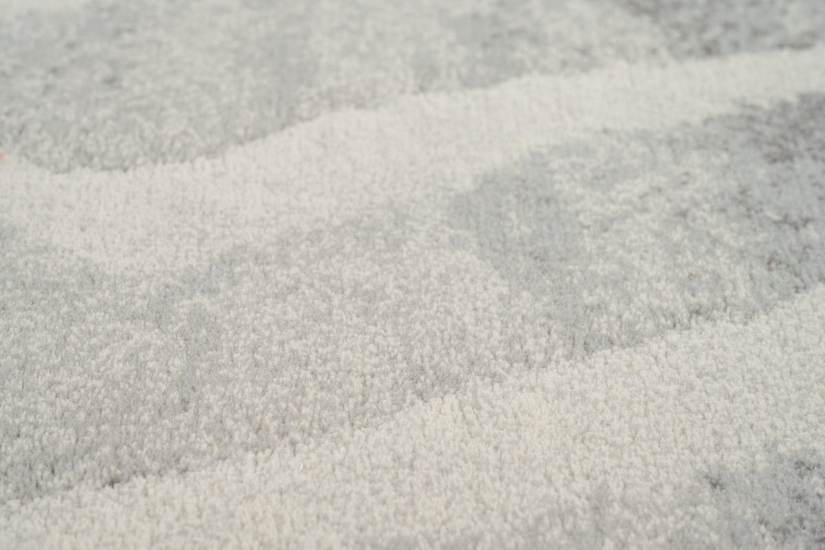 Gros plan sur le velours ras et dense du tapis Tapison Home Torino 063.0990.6797