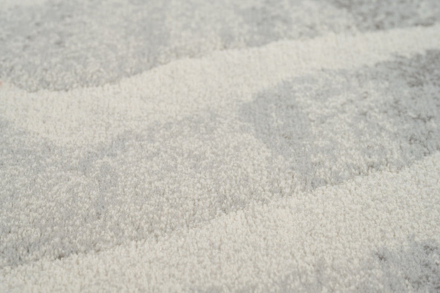 Gros plan sur le velours ras et dense du tapis Tapison Home Torino 063.0990.6797