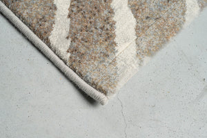 Détail d'un angle du tapis Tapison Home Torino 063.0990.9243 en taupe et ivoire