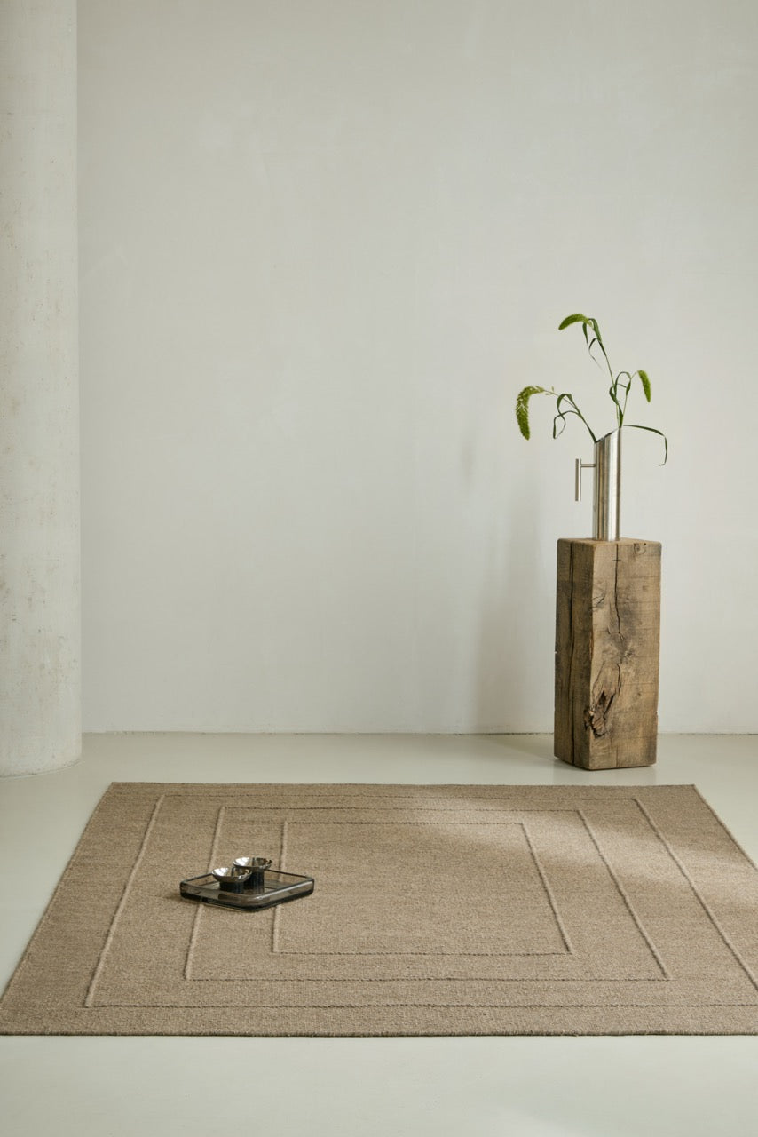 Tapis Brink & Campman Senso Border Fur Brown brun camel aux trois cadres en relief, dans un intérieur