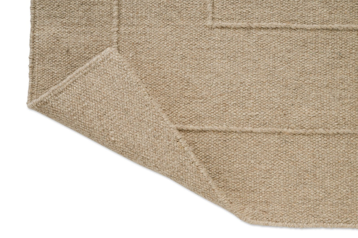 Tapis Brink & Campman Senso Border Natural, détail de l'angle replié et de l'envers