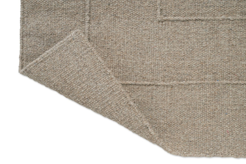 Tapis Brink & Campman Senso Border Soft Taupe, détail de l'angle replié et de l'envers