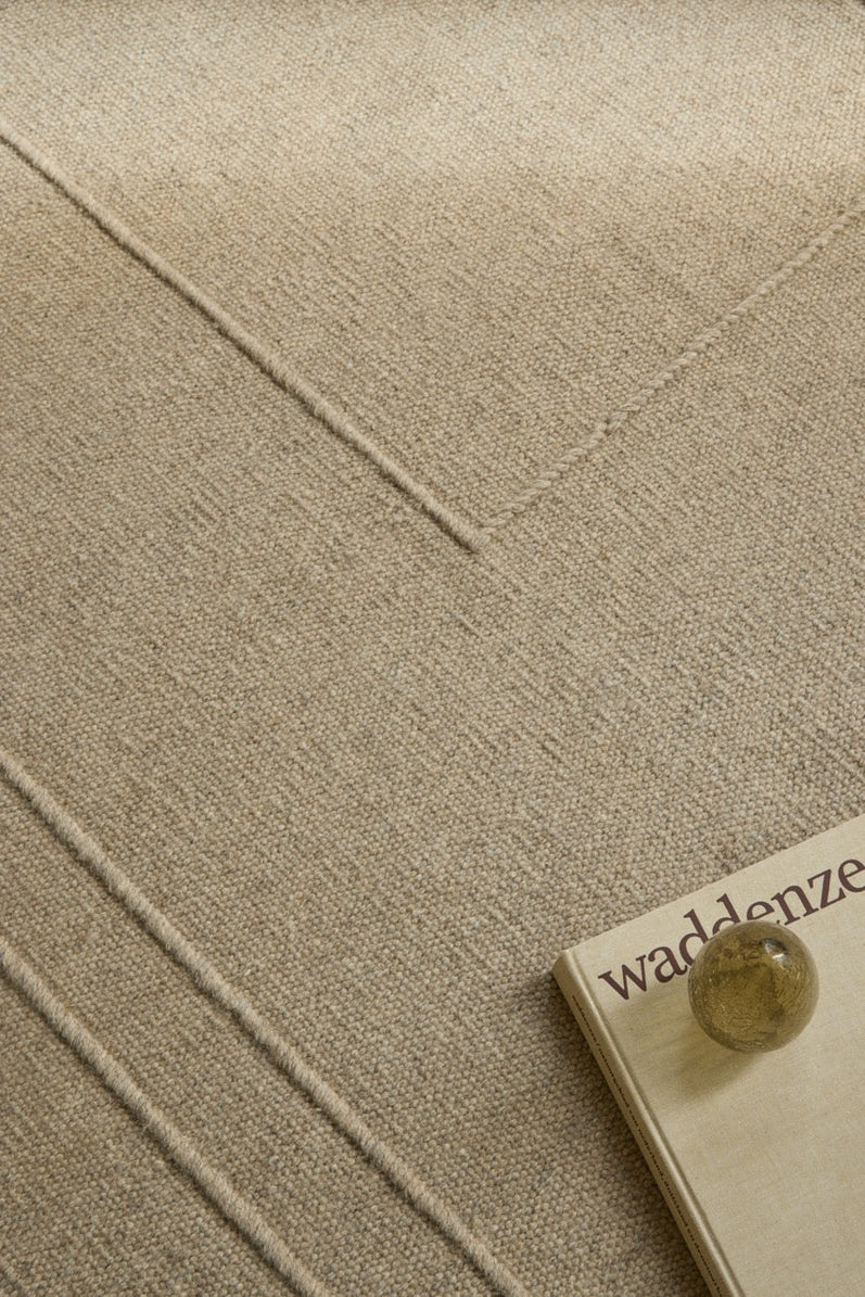 Tapis Brink & Campman Senso Planes Natural beige sable aux rectangles superposés en relief, dans un intérieur, deuxième vue