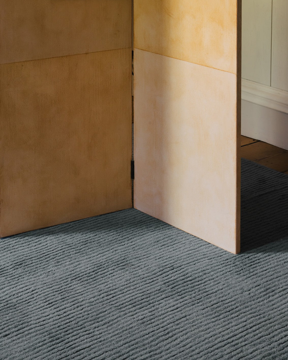Tapis bleu gris Layered Drift Wool Dusty Blue, gros plan dans un intérieur