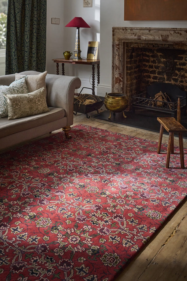Tapis Morris & Co Persian Scroll Plum rouge chaud, crème, olive et aubergine, dans un intérieur