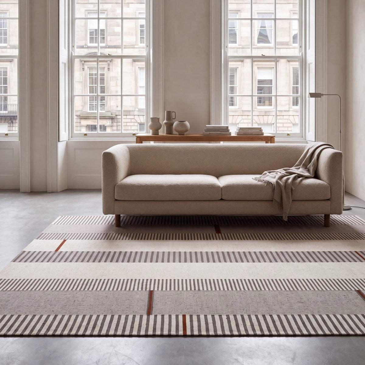 Tapis Acsento Oslo Grey Terra gris à rayures ivoire et anthracite, touches de terracotta, dans un intérieur, deuxième vue