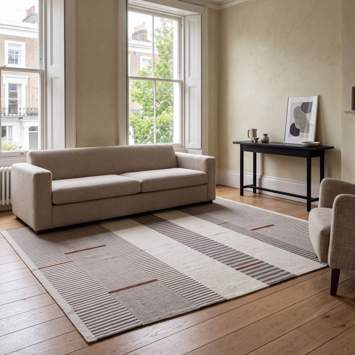 Tapis Acsento Oslo Grey Terra gris à rayures ivoire et anthracite, touches de terracotta, dans un intérieur