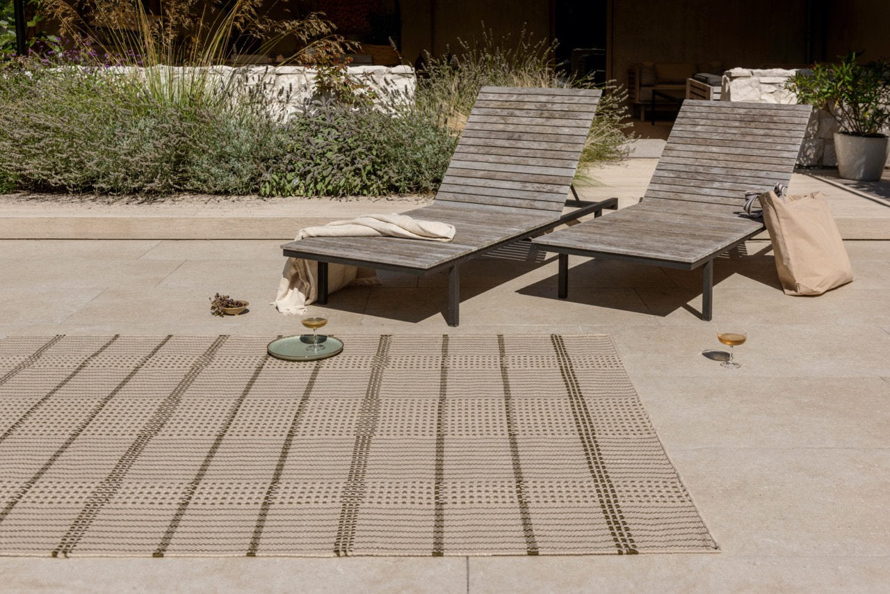 Exterior lounge featuring Zona Stitch Olive rug with modern seating on tiled patio